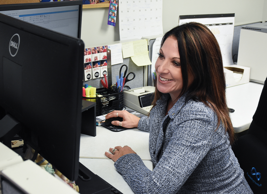 Payroll Pros employee smiling at her desk.