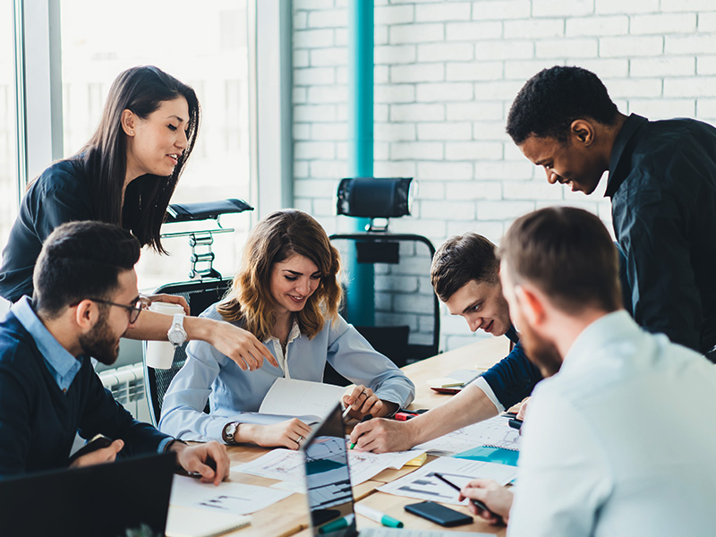 A group of co-workers collaborating around a conference table.